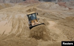 一名中国工人在江西南城县的稀土工地上驾驶推土机。（资料照片）