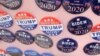  FILE - Biden for President campaign buttons are for sale beside "Impeach Trump Now!" buttons as U.S. Democratic presidential candidate and former Vice President Joe Biden meets union workers at the Teamsters Local 249 hall in Pittsburgh, April 29, 2019.