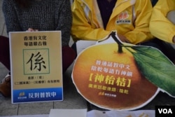 新民主同盟送紙製的「神枱吉」給教育局局長吳克儉，寓意教育局「陰乾」廣東話，矮化廣東話在香港的地位。（美國之音湯惠芸攝）