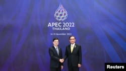 香港特首李家超（左）2022年11月18日在出席亞太經合組織峰會期間與東道主泰國總理握手。 （亞太經合組織2022年峰會照片）