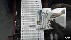 资料照片：肯尼亚首都内罗毕一家印刷厂的技术人员正在检查当地中国人拥有的《中国日报》（2014年1月3日）