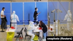 抵達上海虹橋國際機場的旅客在接受新冠核酸檢測。（2022年10月12日）