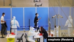 资料照：抵达上海虹桥国际机场的旅客在接受新冠核酸检测。 （2022年10月12日）