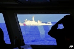 ແຟ້ມ - ໃນ​ຮູບນີ້ ສະ​ໜອງ​ໂດຍ​ໜ່ວຍ​ຍາມ​ຝັ່ງ​ຟີ​ລິບ​ປິນ ສາ​ມາດ​ແນມ​ເຫັນ​ກຳ​ປັ່ນ​ຂອງ​ໜ່ວຍ​ຍາມ​ຝັ່ງ​ຈີນ ທີ່​ແລ່ນ​ຢູ່​ໃກ້ໆ​ກຳ​ປັ່ນ​ຍາມ​ຝັ່ງ​ຂອງ​ຟີ​ລິບ​ປິນ ໃນ​ລະ​ຫວ່າງ​ການ​ລາດ​ຕະ​ເວນ​ທີ່ Bajo de Masinloc ເມື່ອ​ວັນ​ທີ 2 ມີ​ນາ 2022.