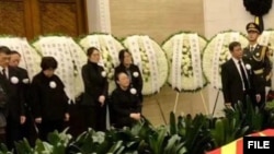 李克強遺體告別現場，其遺孀程虹女士由女兒和親友陪伴坐在家屬席。（網友轉發圖片）