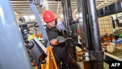 中國山東省青州市的一個鏟車工廠的工人在組裝鏟車。（2023年10月18日）