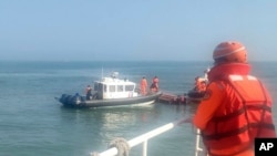 台灣海巡署公佈照片顯示2024年2月14日海巡人員在金門海域調查一艘中國籍快艇越界進入禁區水域。