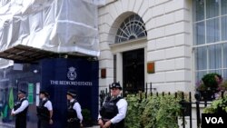 示威者在2023年7月1日到在倫敦的香港經濟貿易辦事處，悼念兩年前7月1日在香港銅鑼灣刺警後自殺身亡的梁健輝，經貿辦外有七名警員看守 （美國之音/鄭樂捷）