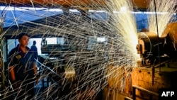 中國山東省青州市一個汽車輪圈工廠的工人正在生產線上工作。 （2024年6月17日）