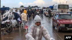 2024 年 2 月 2 日，以色列與哈馬斯武裝之間的戰鬥迫使許多加沙居民離開家園，他們聚集在加沙地帶南部的汗尤尼斯。巴勒斯坦兒童穿著冠狀病毒大流疫留下的防護服。