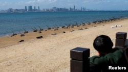 一個男孩從台灣金門島海岸遙望中國廈門市。（2024年2月21日）