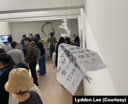 倫敦“白紙週年”藝術展上觀眾觀看作品。（美國之音 李伯安）