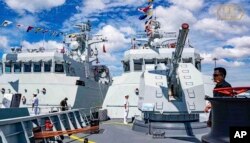 ໃນຮູບທີ່ໄດ້ຮັບການເຜີຍແຜ່ໂດຍເຟສບຸກເພຈ໌ທາງການ ຂອງຖານທັບເຮືອ ຣີມ (Ream), ກໍປັ່ນຂອງກອງທັບເຮືອກໍາປູເຈຍ ທະການເຮືອກໍາປູເຈຍ ຢືນລາດຕະເວນຢູ່ທີ່ຖານທັບເຮືອຣີມ ໃນສີຫານຸກວີລ, ພາກຕາເວັນຕົກສຽງໃຕ້ຂອງພະນົມເປັນ, ວັນທີ 3 ທັນວາ 2023.