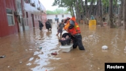 中國救援人員在房山縣救助疏散受到洪水襲擊的一名幼童。（2023年7月31日）