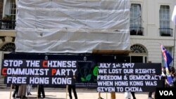 示威者在2023年7月1日到在倫敦的香港經濟貿易辦事處，悼念兩年前7月1日在香港銅鑼灣刺警後自殺身亡的梁健輝. （美國之音/鄭樂捷）