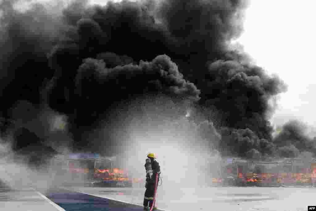 A firefighter sprays water to control the burning of seized illegal drugs during a destruction ceremony to mark the U.N.&#39;s &quot;International Day against Drug Abuse and Illicit Trafficking&quot; in Yangon, Myanmar.