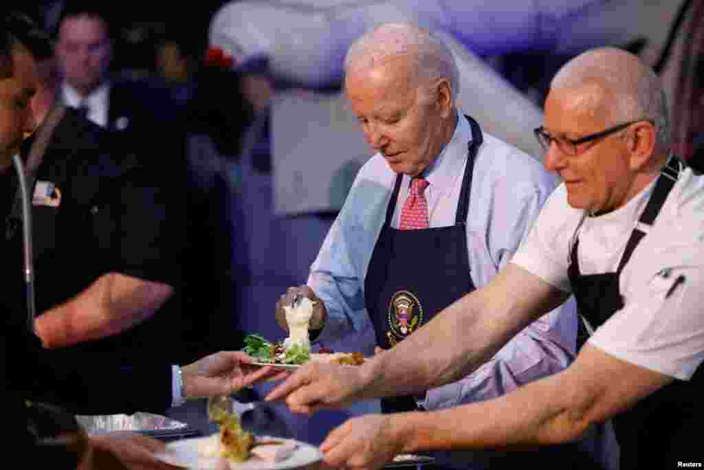 Antes de comenzar los festejos de Acción de Gracia, el presidente Biden y el chef Robert Irvine sirvieron comida a los miembros del servicio y sus familias durante un evento , Friendsgiving, en la Estación Naval de Norfolk en Norfolk, Virginia, EEUU, el 19 de noviembre de 2023.