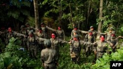 FILE - Guerrillas of the New People's Army (NPA) are seen in formation in the Sierra Madre mountain range, east of Manila, on July 30, 2017.