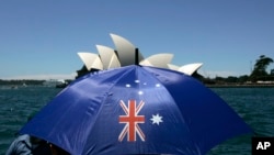 資料照 - 澳大利亞國慶日，悉尼港一位婦女撐開印有澳大利亞國旗圖案的遮陽傘。