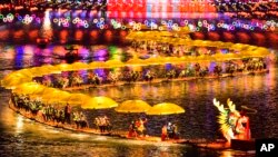 中共官媒新华社发布照片显示，游客们在湖北省宣恩县乘坐竹筏参加迎新春灯会游湖活动。（2024年2月11日）