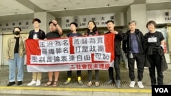 香港社民連8名成員及義工，被當局票控街頭無牌籌款及未經准許而展示海報，他們2月21日在東區裁判法院外拉起橫額示威，抗議當局”法治為名、打壓言論自由”。(美國之音/湯惠芸)