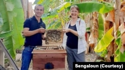 ອາຈານແສງອາລຸນ ແລະແຂກຕ່າງປະເທດ ທີ່ມາຢ້ຽມຢາມ ແລະຖອດຖອນບົດຮຽນ ຈາກການລ້ຽງເຜິ້ງທໍາມະຊາດ ໃນຟາມລ້ຽງເຜິ້ງ ບ້ານນາຊູ, ເມືອງໂພນໂຮງ, ແຂວງວຽງຈັນ.