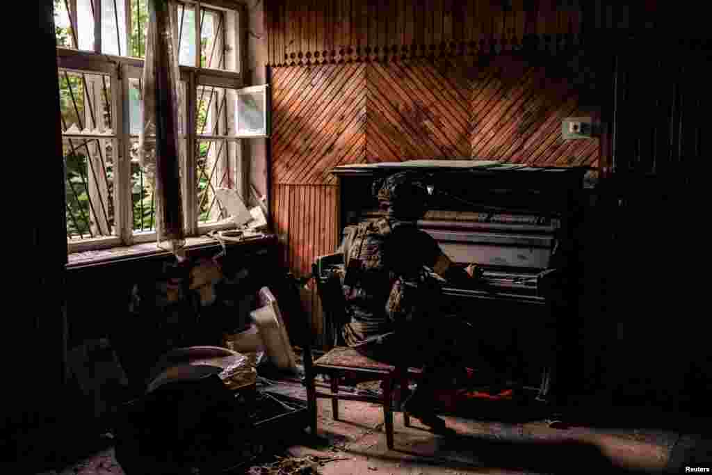 A serviceman plays a piano in a damaged building in the front-line town of Chasiv Yar in Donetsk region, Ukraine. (Oleg Petrasiuk/Press Service of the 24th King Danylo Separate Mechanized Brigade of the Ukrainian Armed Forces/Handout via Reuters)
