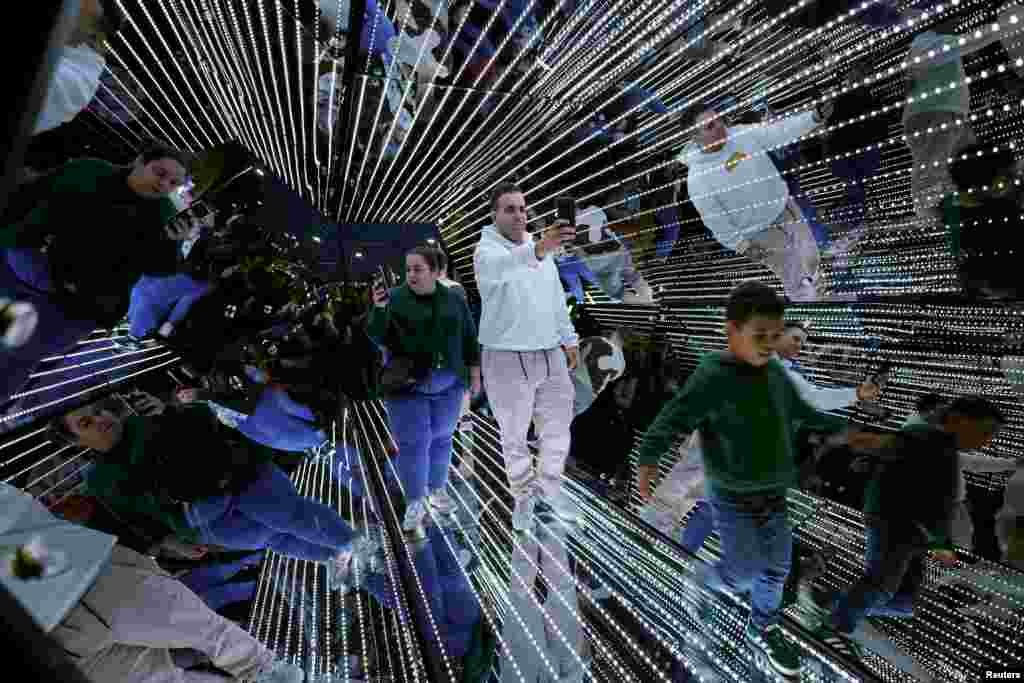 People walk through Passengers by Tetro+A &amp; Yam during The White Night (in Basque, Gau Zuria) commemorating the founding of the Villa of Bilbao with light shows, music, art and literature at venues throughout the city in Bilbao, Spain, June 15, 2024.