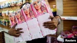 资料照片: 搬运工人将玩具制造商美泰制造的芭比娃娃放在货架上