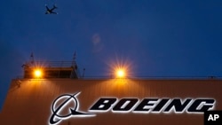 资料照片：一架飞机飞过西雅图波音机场波音公司新扩建的737交付中心。(2015年10月19日)