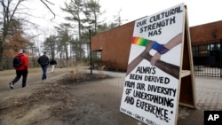 ແຟ້ມ-ບັນດານັກຮຽນ ພາກັນຍ່າງຜ່ານປ້າຍທີ່ຈັດສະແດງຂຶ້ນໄວວາ ລຸນຫຼັງມີເຫດການກ່ຽວກັບເຫດການຕໍ່ຕ້ານຢູ່ໃນຂົງເຂດມະຫາວິທະຍາໄລ, ຢູ່ທີ່ມະຫາວິທະຍາໄລນະວແຮໃເຊີ ໃນເມືອງເດີແຮມ, ລັດນິວແຮມເຊີ, ວັນທີ 19 ເມສາ 2018. 