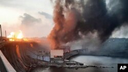 На фотографии, предоставленной Telegram-каналом премьер-министра Украины Дениса Шмыгаля, дым и огонь поднимаются над Днепровской ГЭС после российских атак. 22 марта 2024 года.