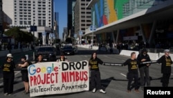 นักเคลื่อนไหวและพนักงานเทคโนโลยีออกมาคัดค้าน Project Nimbus ของอกกูเกิลและแอมะซอน ที่แคลิฟอร์เนีย เมื่อ 23 ส.ค. 2023 (REUTERS/Loren Elliott)