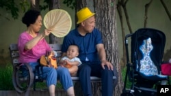 北京公园里一对老夫妇和一名幼儿在乘凉。（2023年6月29日）