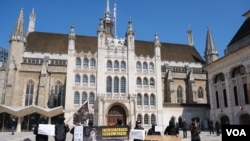 反對香港財經事務及庫務局局長許正宇訪問倫敦的示威者在金融城市政廳（Guildhall）外手持抗議標語 （美國之音/鄭樂捷）