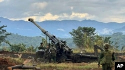 資料照片：一個少數民族武裝團體的成員在緬甸撣邦辛威鎮的一座山上檢查據稱從緬甸軍隊前哨基地繳獲的武器。(2023年11月24日)