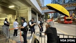 香港社運人士王婆婆4月24日傍晚在高等法院囚車出入口外，撐黃傘及高呼口號，聲援被還柙的支聯會國安案3名被告李卓人、何俊仁及鄒幸彤。(美國之音)