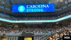 北卡羅萊納大學教堂山分校2023年8月30日舉行燭光守夜活動，悼念在數天前的槍擊案中遇難的教授嚴資傑，大屏幕上顯示著“北卡羅萊納大學堅強”的字樣。