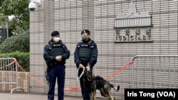 在西九龍裁判法院外駐守的警員牽著的警犬都穿上防刺的裝備。 (美國之音 湯惠芸)