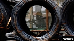 資料照片: 2009年7月9日山西省長治市一名工人走過建築工地的鋼絲卷