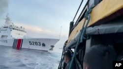 资料照片: 2023年10月22日编号为5203的中国海警船在南中国海碰撞菲律宾军用补给船后，菲律宾船员观望