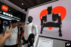 资料照：北京举办的世界机器人大会小米展台上展示的机器人和机器狗图像。（2023年8月16日）