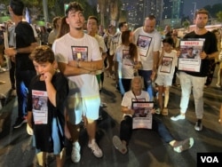 原本在广场上与群众一起等待会议报告的人质家属逐渐失去耐心、开始发声抗议，由广场转移阵地到街道上中断交通。当警察尝试恢复交通秩序，一位人质（Jonathan Samerano）的祖母干脆坐在街道上、手拿孙子的海报、带领群众呐喊“现在就交换他们”。(美国之音/赖素芬)