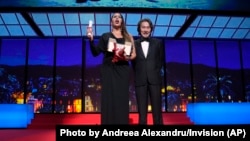 Karla Sofia Gascon, left, holds the award for best actress for 'Emilia Perez,' alongside Koji Yakusho, during the 77th international film festival, Cannes, France, May 25, 2024.