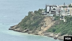 香港島南區豪宅紅山半島獨立屋向海山坡，世紀暴雨後發生大規模山泥傾瀉，並揭發有僭建或霸佔官地等違法行為，各界質疑當局執法有雙重標準之嫌。（美國之音/湯惠芸）