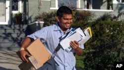 资料照片：2024年3月22日，美国邮局邮递员加布里埃尔·佩尼亚在洛杉矶投送邮件。(美联社照片)