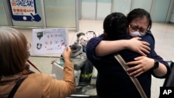 北京首都國際機場一名女子等到了乘坐國際航班抵達北京的親人。（2023年3月14日）