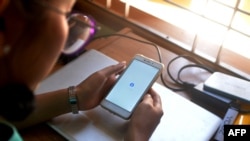 (ພາບ​ໃນ​ແຟມ) ແມ່​ຍິງ​ຜູ້​ນຶ່ງ​ໃຊ້​ມື​ຖື​ຂອງ​ນາງ​ເພື່ອກວດ​ເບິ່ງ Facebook ​ໃນ​ນະ​ຄອນ​ຫລວງ​ເນ​ປີ​ດໍ, 16 ມີ​ນາ, 2021 ໃນ​ຂະ​ນະ​ທີ່ເຈົ້າ​ໜ້າ​ທີ່​ມຽນ​ມາ​ສັ່ງ​ໃຫ້​ບໍ​ລິ​ສັດ​ໂທ​ລະ​ຄົມຈຳ​ກັດ​ການ​ບໍ​ລິ​ການ​​ເຄືອ​ຂ່າຍ​ຂໍ້​ມູນ​ໃນ​ມື​ຖື ຫລັງ​ຈາກ​ການກໍ່​ລັດ​ຖະ​ປະ​ຫານ​ໃນເດືອນ​ກຸມ​ພາ