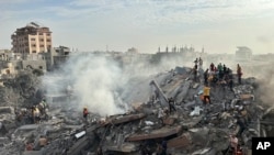 2023年10月31日，以色列空袭加沙地带努塞拉特难民营后，巴勒斯坦人寻找幸存者。（美联社照片）