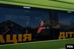 居民丽迪娅坐在巴士内，等待撤离库皮扬斯克。(2023年8月19日，美国之音博夏特拍摄)